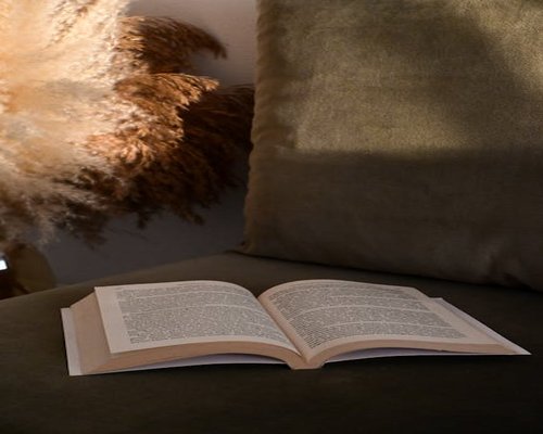 Lettura di un libro cartaceo sul divano con luce calda